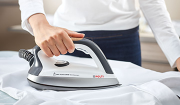 La imagen muestra la suela de Polti Vaporella Next VN18.25 deslizandose sobre una camisa blanca mientras se plancha