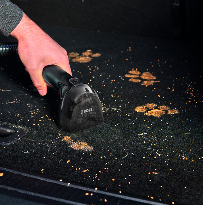 Una persona extrayendo pelo de la pistola limpiadora de manchas