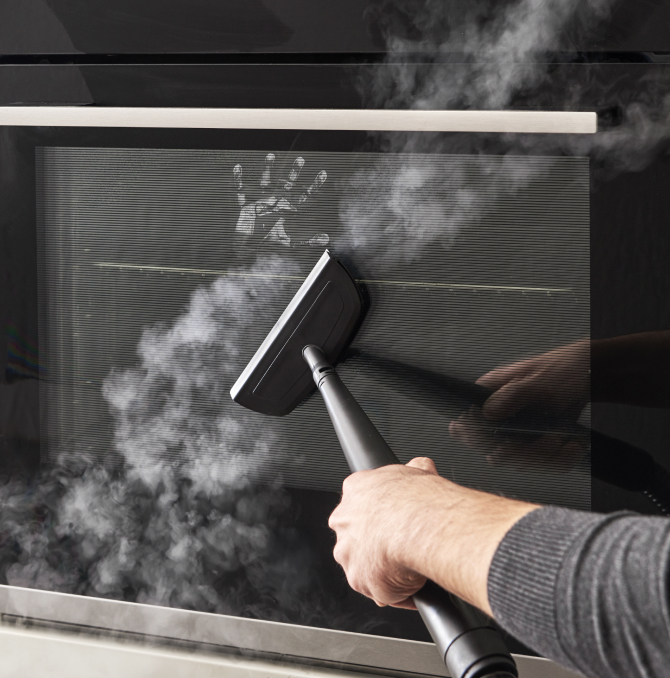 una persona limpiando el espejo del horno